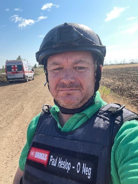 A person wearing a helmet and a vest

Description automatically generated