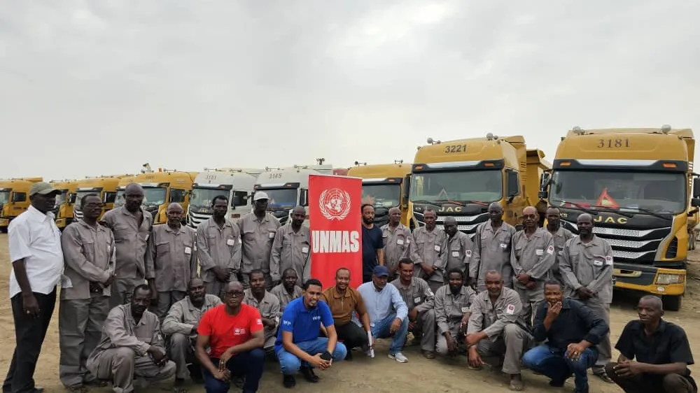 a group of men in front of several trucks