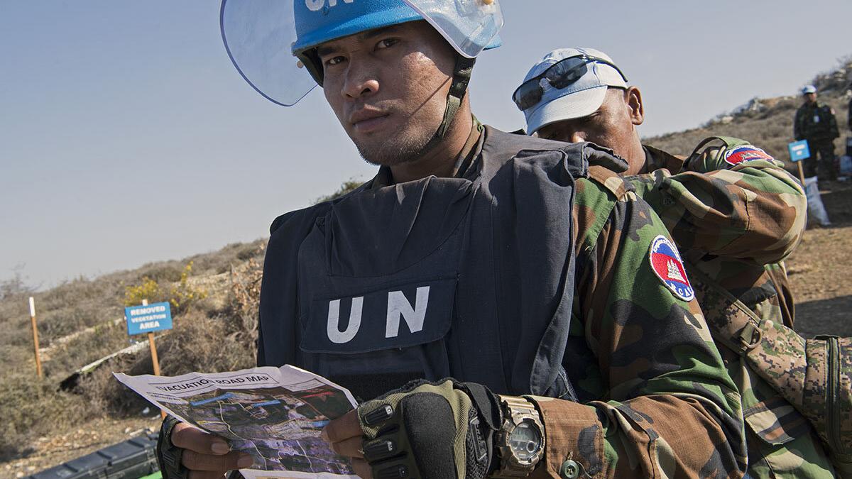 A Cambodian team leader revises safety requirements before entering the hazardous area on a minefield near Rmeish, south Lebanon.