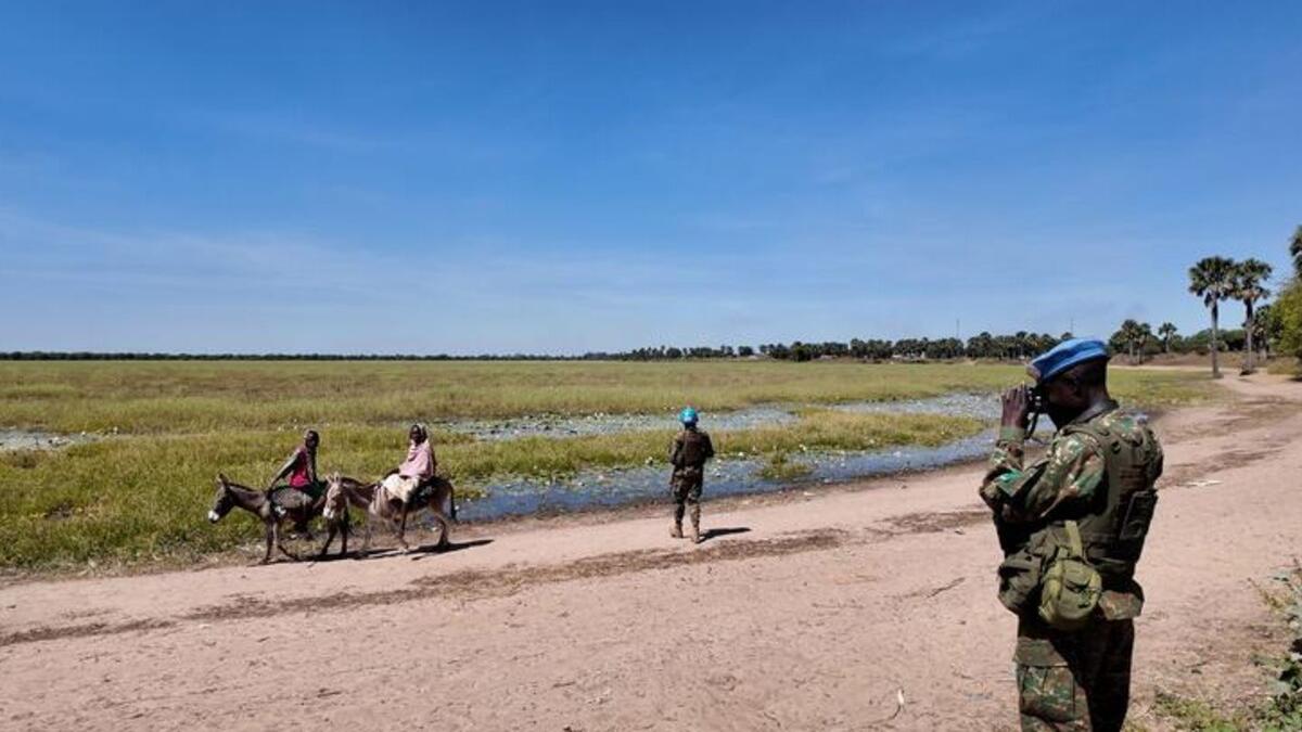 Des villageois à dos d'âne, des soldats de la force de maintien de la paix en patrouille.