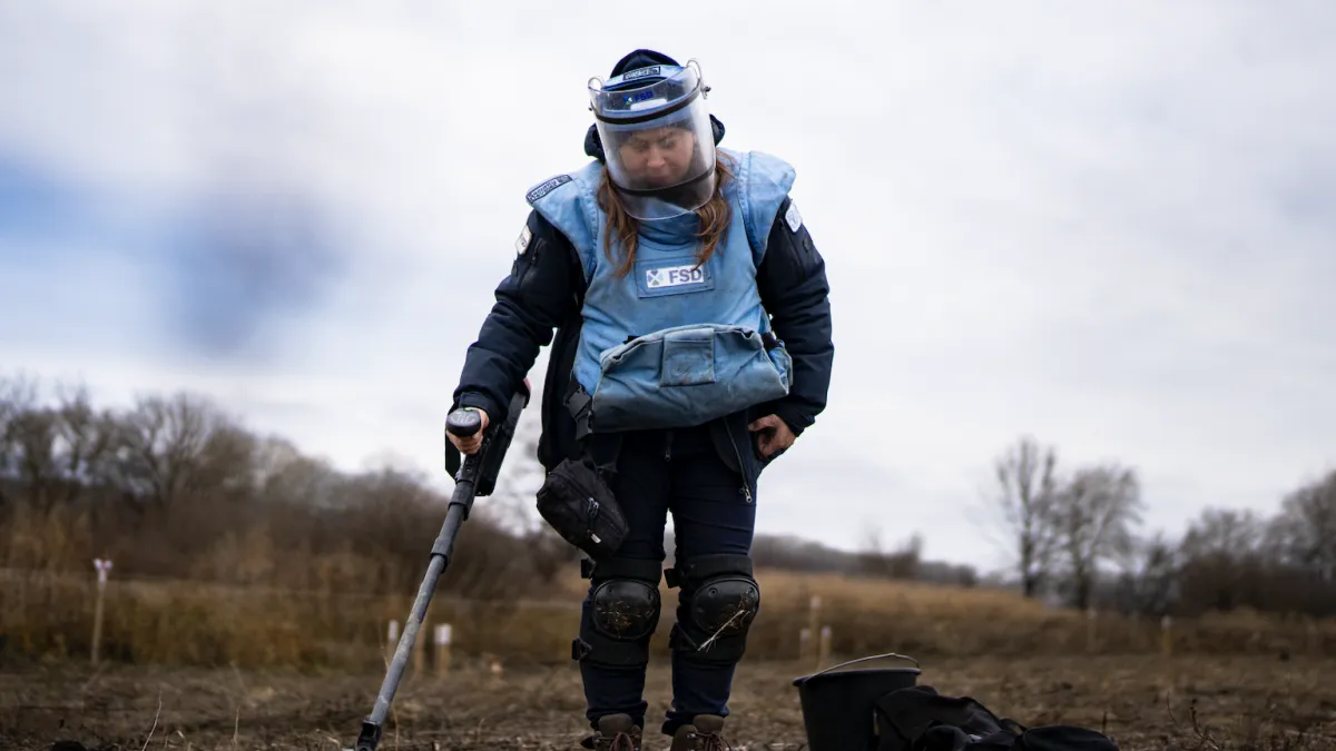 a female deminer is working in a field
