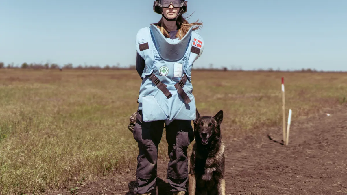 Portrait of Maria Radchenko, a mine detection dog handler, with her dog.