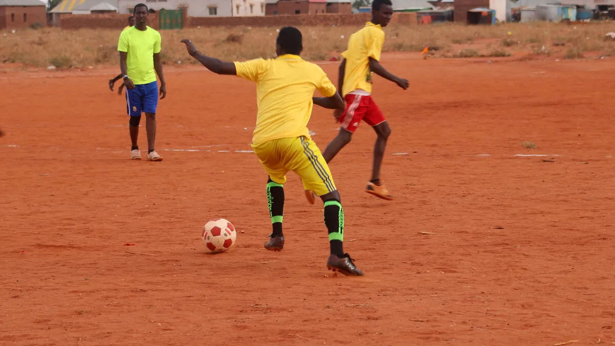 Youth playing football on a recently cleared parcel of land