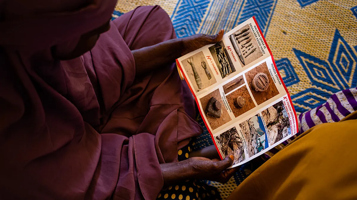 a woman is holding and reading a flyer