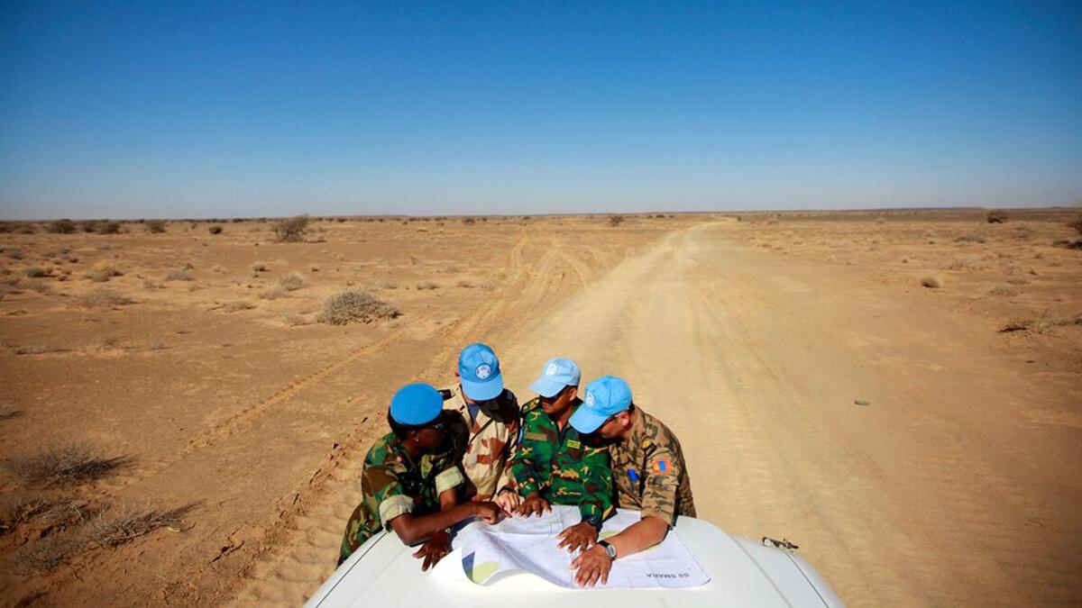 some peacekeepers are discussing on a car