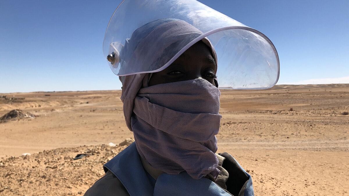 a female deminer with a protective mask