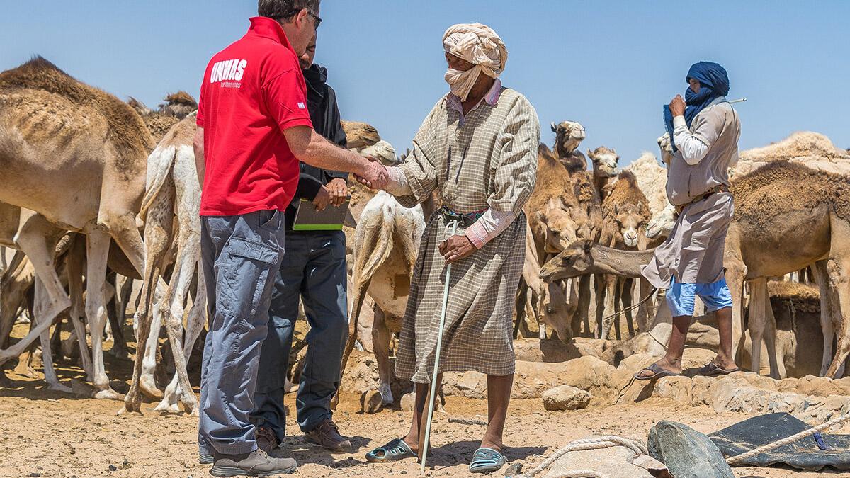 an unmas staff is shaking hand with a villager