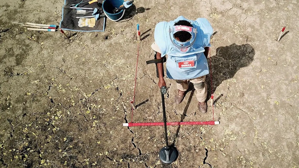 A person clearing landmines
