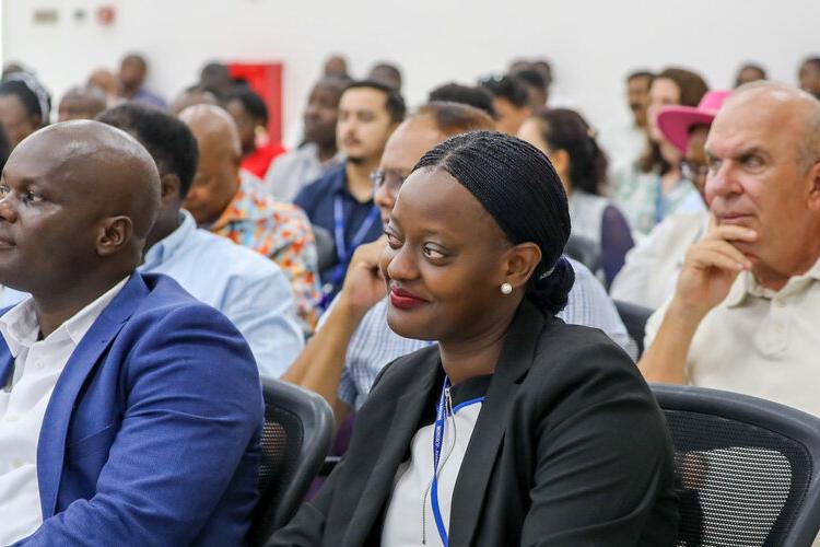 An audience of people listening to a speaker on stage (not pictured).