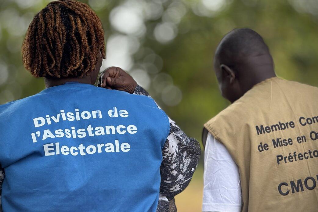 Un représentant porte une veste avec les mots « Division de l’Assistance Électorale ».