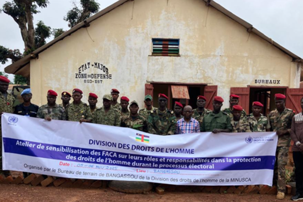 Les soldats de la paix tiennent une banderole avec le texte « Division des Droits de l'Homme ».