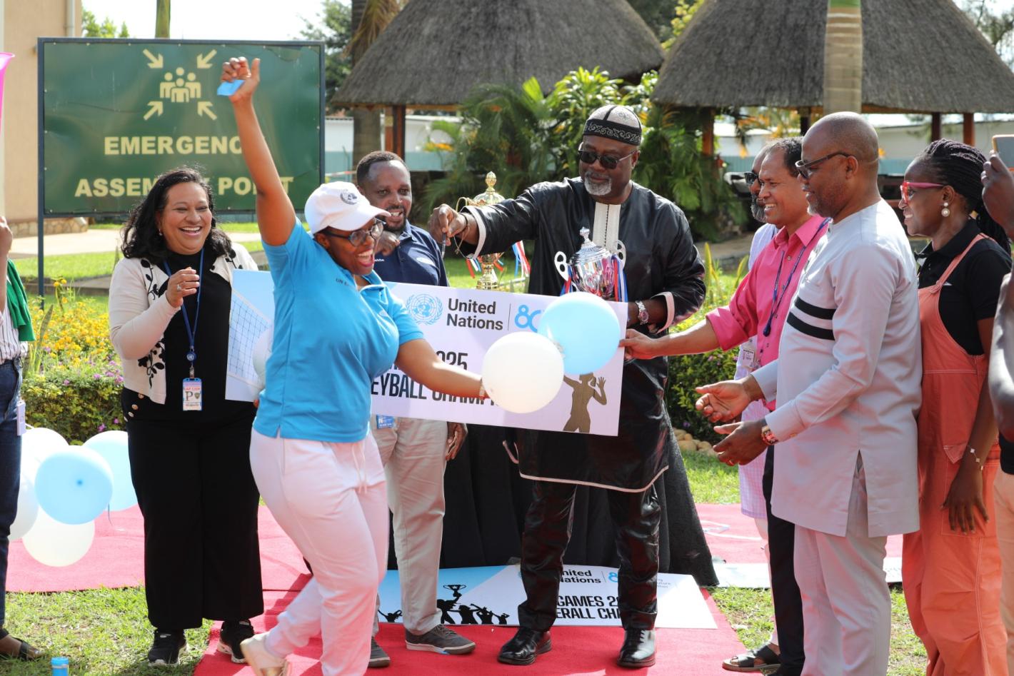 UN staff celebrate in front of a UN banner