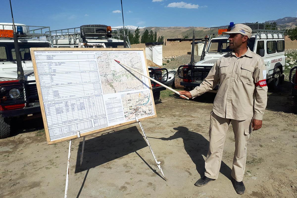 a man is pointing on a briefing board