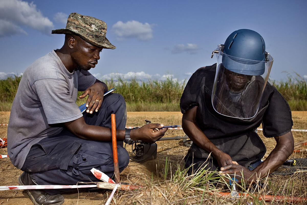 two deminers are working on a field