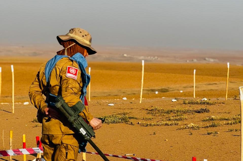 a woman is conducting mine clearance operation in a field