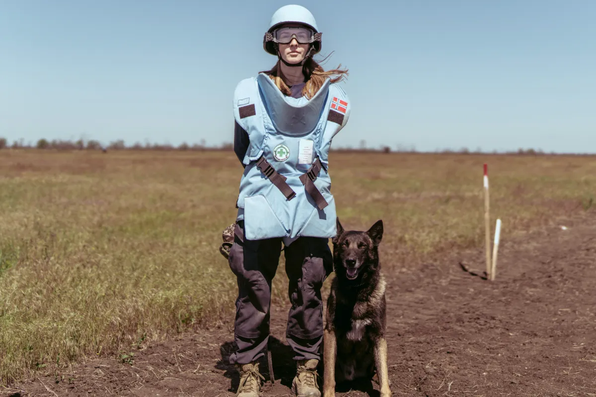 Portrait of Maria Radchenko, a mine detection dog handler, with her dog.