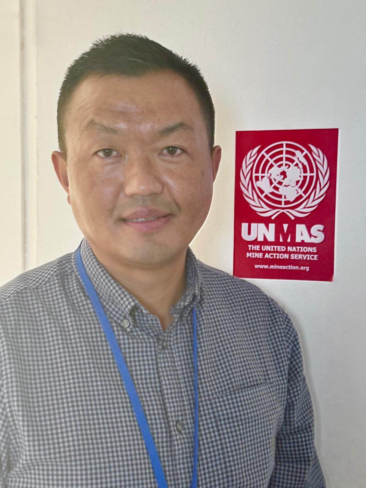 a man's headshot with an red logo behind